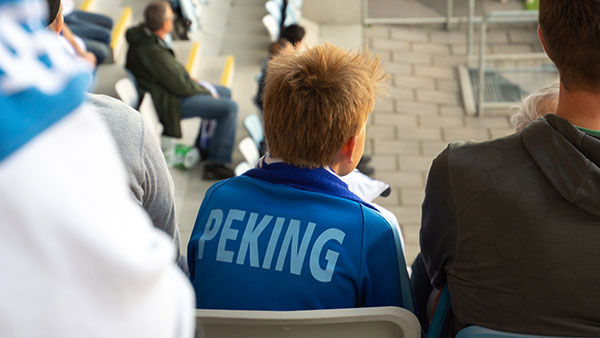 En pojke med förälder på Svenska kyrkans familjeläktare på IFK Norrköpings match.