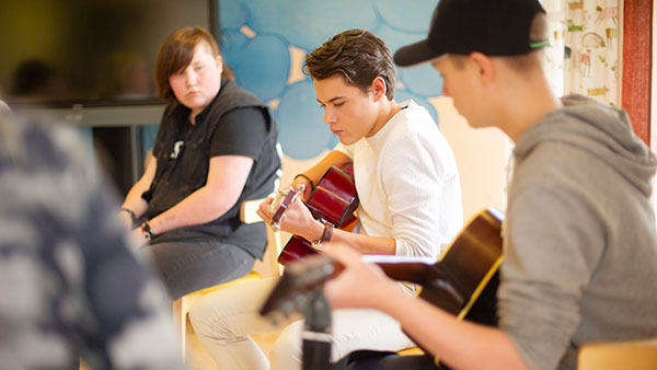 Konfirmander som spelar gitarr.